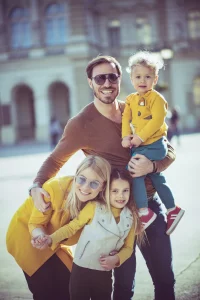 Family taking photo in front of building