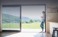 Person leaning on doorway showing countryside view