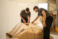 People wrapping package in a warehouse