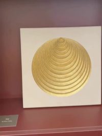 A gilded artwork displayed on the stand