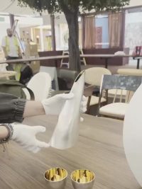 Gloved hands setting silver tableware on the communal table