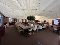 The finished communal table at A Seat at the Table, with every chair in place beneath the olive tree